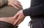 dad caresses pregnant belly